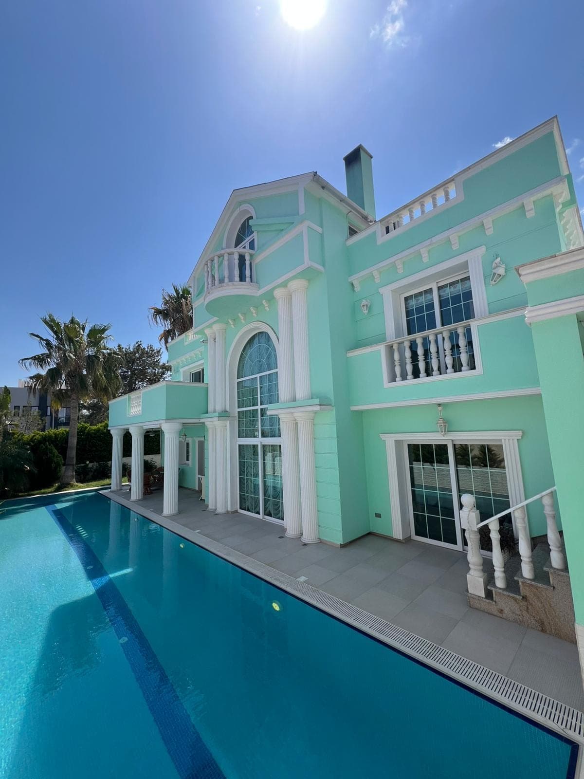 Detached villa exterior with private pool and palm trees