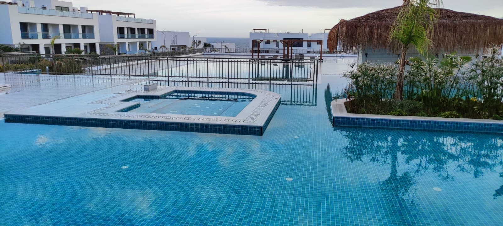 Shared pool and jacuzzi area with sea view