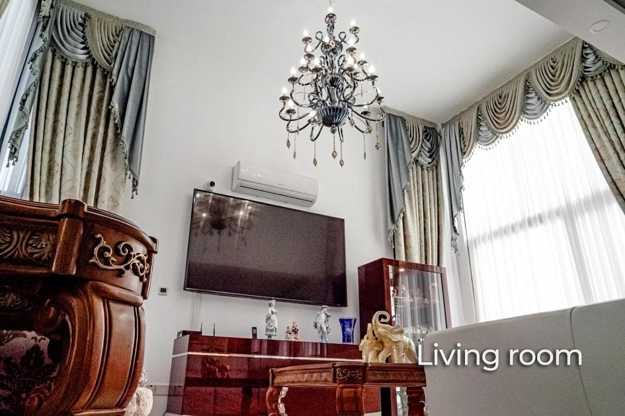Living room with high ceiling, TV unit, air conditioner, and chandelier
