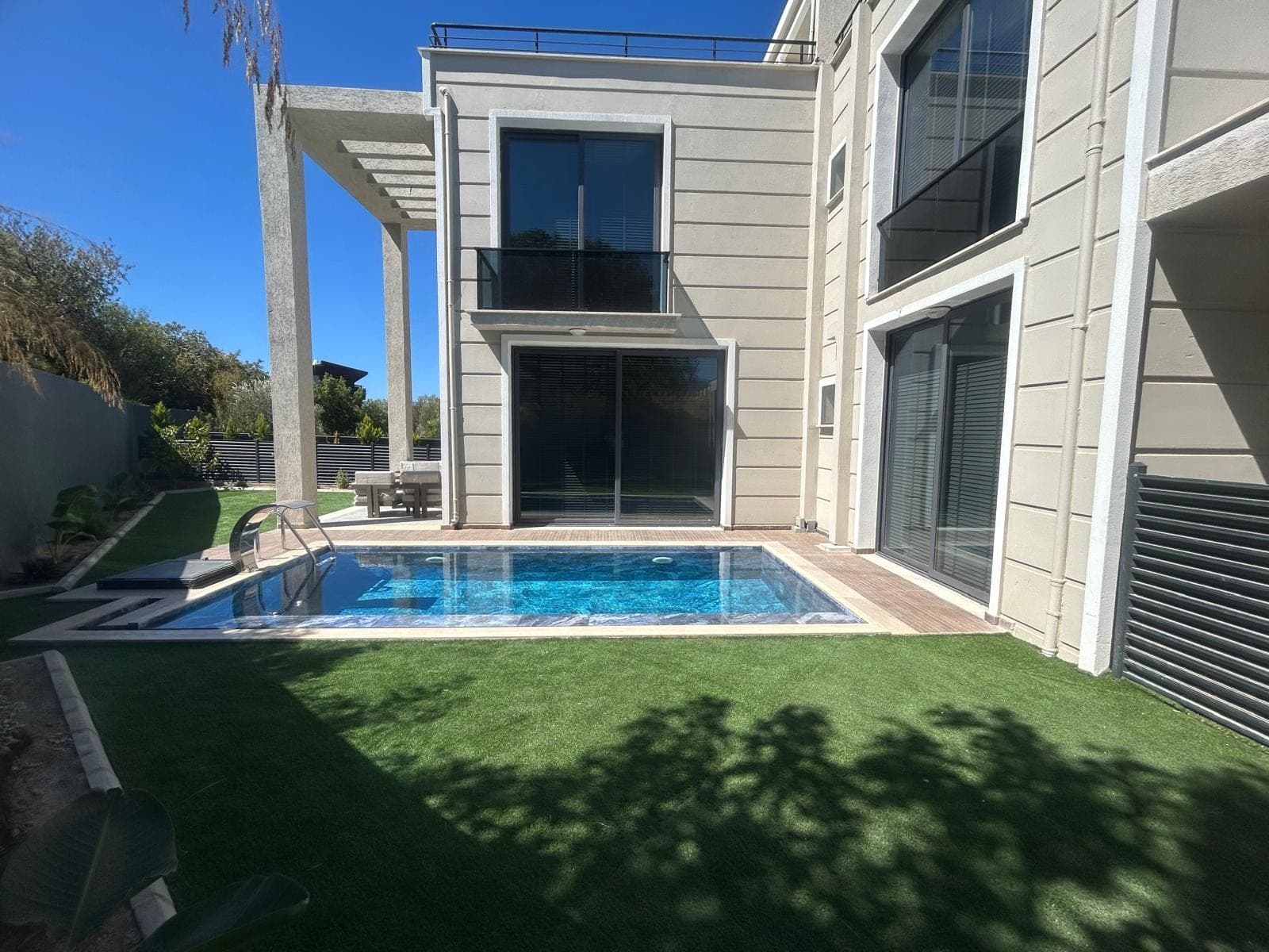 Modern villa exterior with private pool and lawn garden