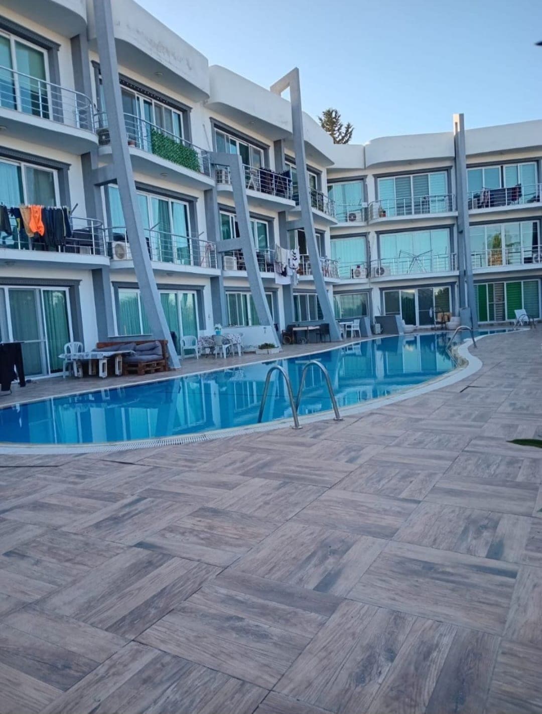 Exterior of a multi-story building with shared pool and balconies