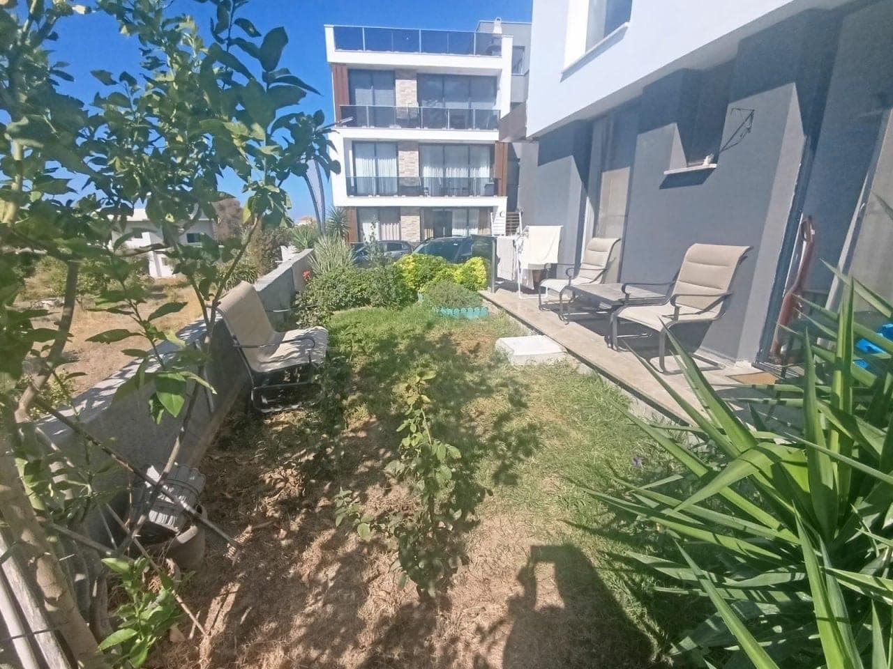 Green area and outdoor parking in front of the apartment building.