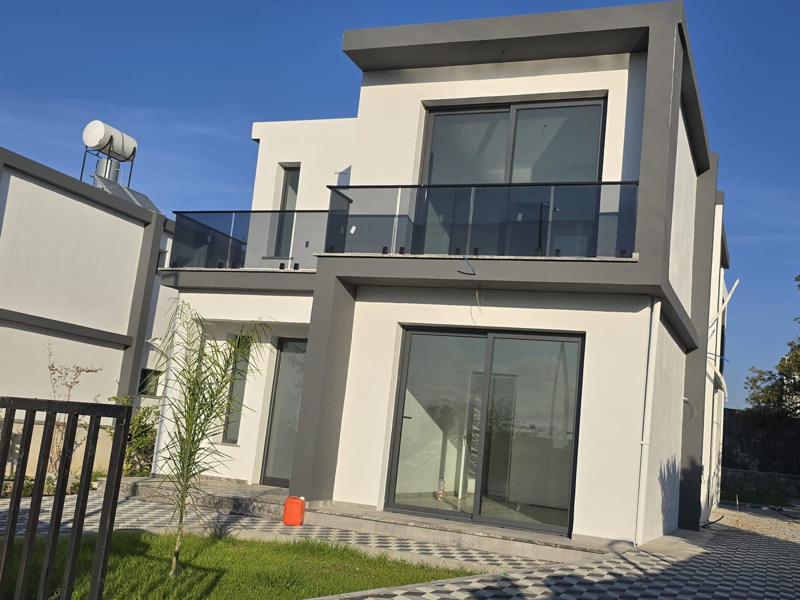 Modern architecture villa exterior in white and grey tones, small garden.