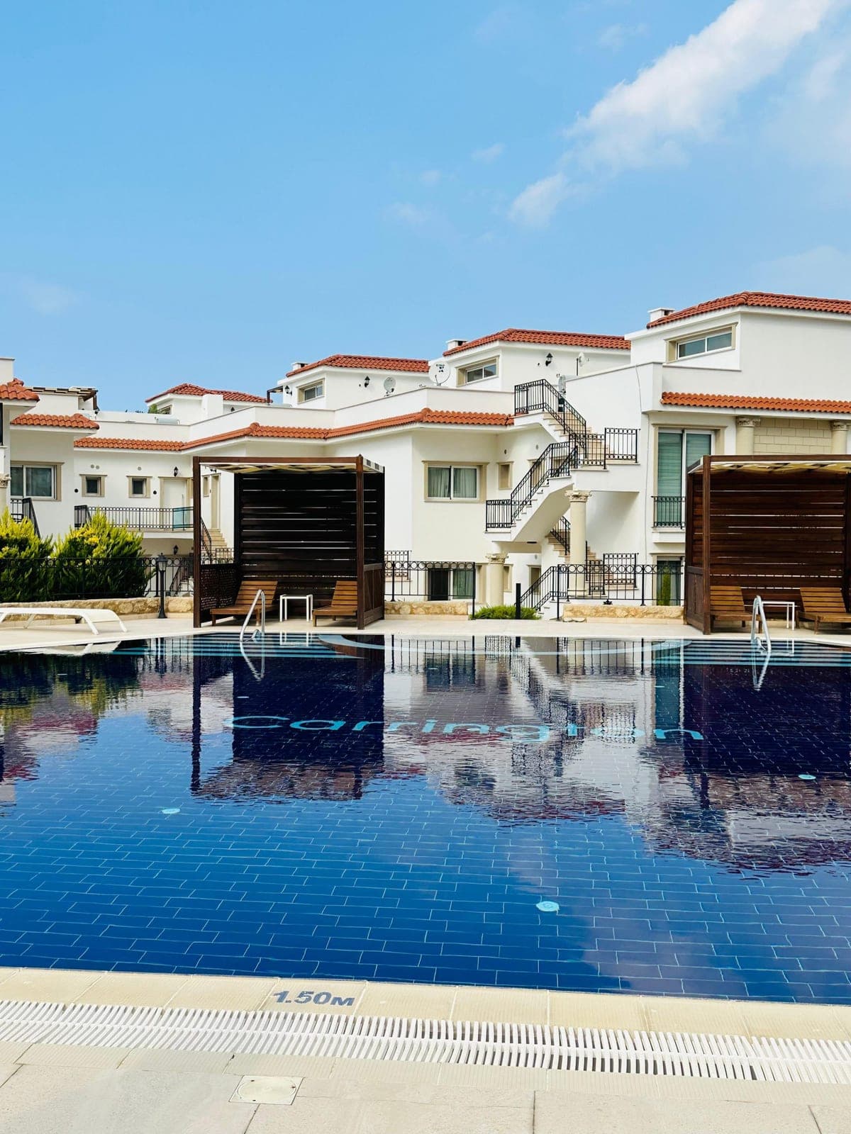Shared swimming pool and lounge areas in front of the row houses.