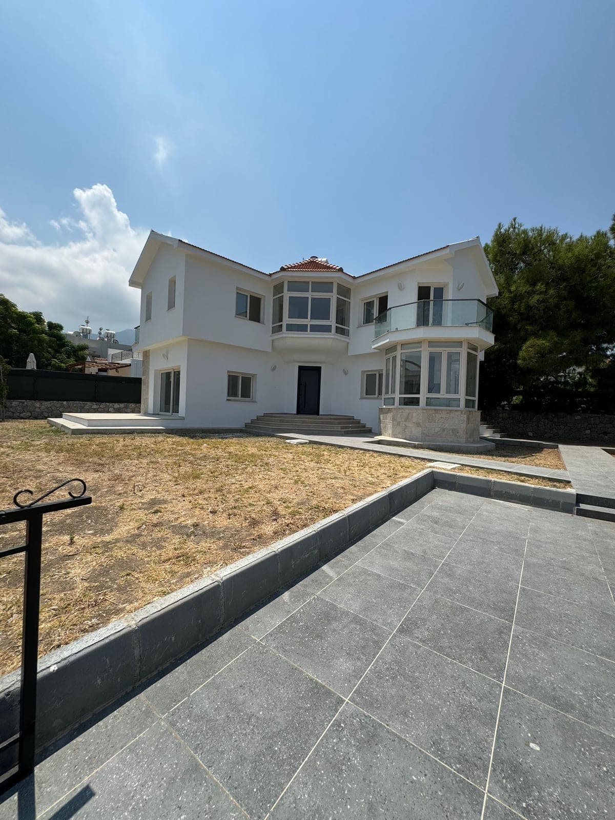 Geniş bahçeli, çok pencereli, modern müstakil villa dış cephesi