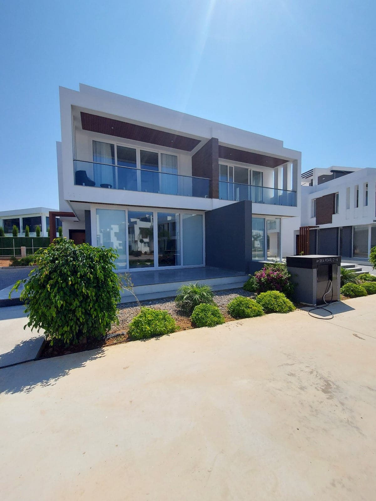 Modern mimariye sahip, bahçeli ve balkonlu müstakil villa dış cephesi.