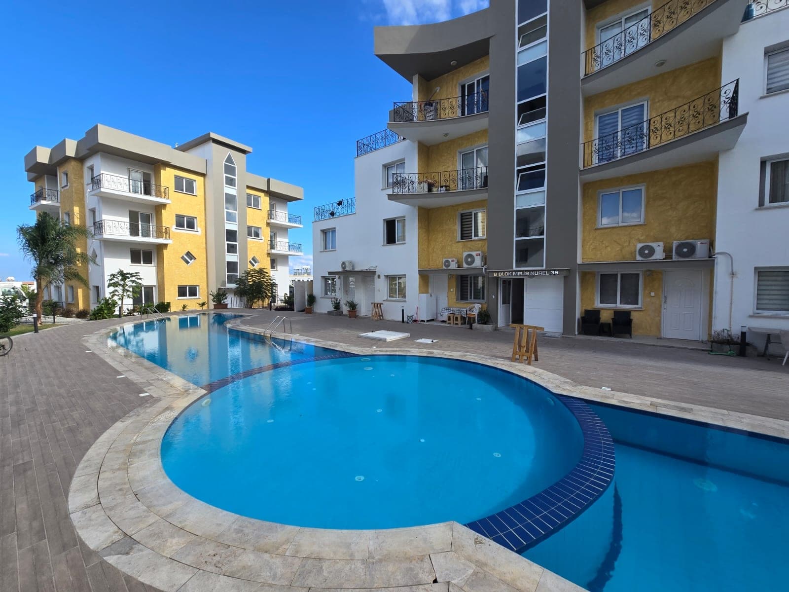 Modern apartman binaları ve önünde ortak kullanımlı yüzme havuzu