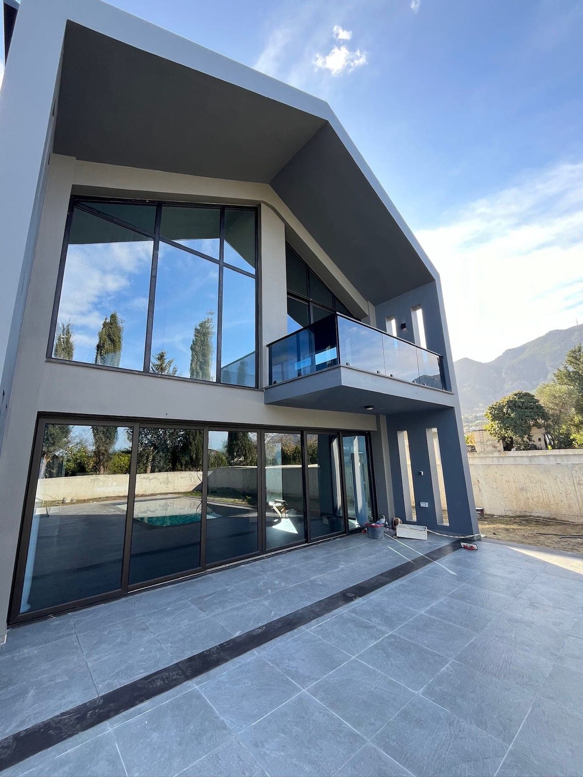 Modern mimarili villa dış cephesi, havuz ve dağ manzarası