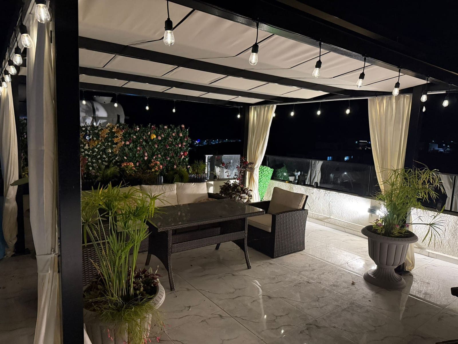 Spacious terrace seating area with city view and lighting