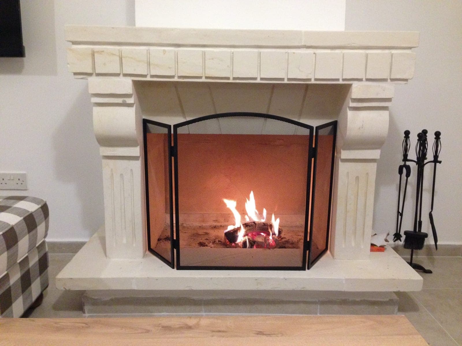 Detail of a lit fireplace with fireplace accessories next to it
