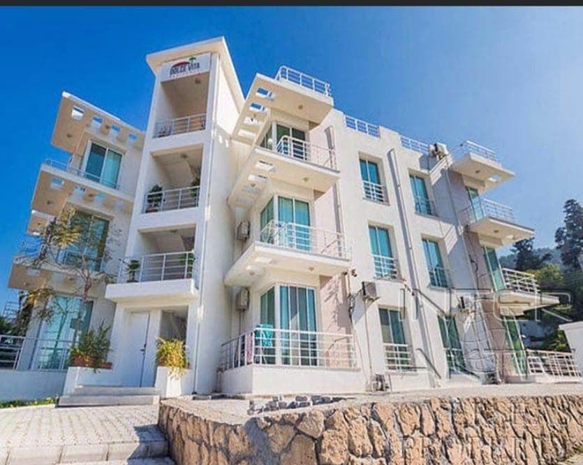 Multi-story apartment building with white facade and balconies