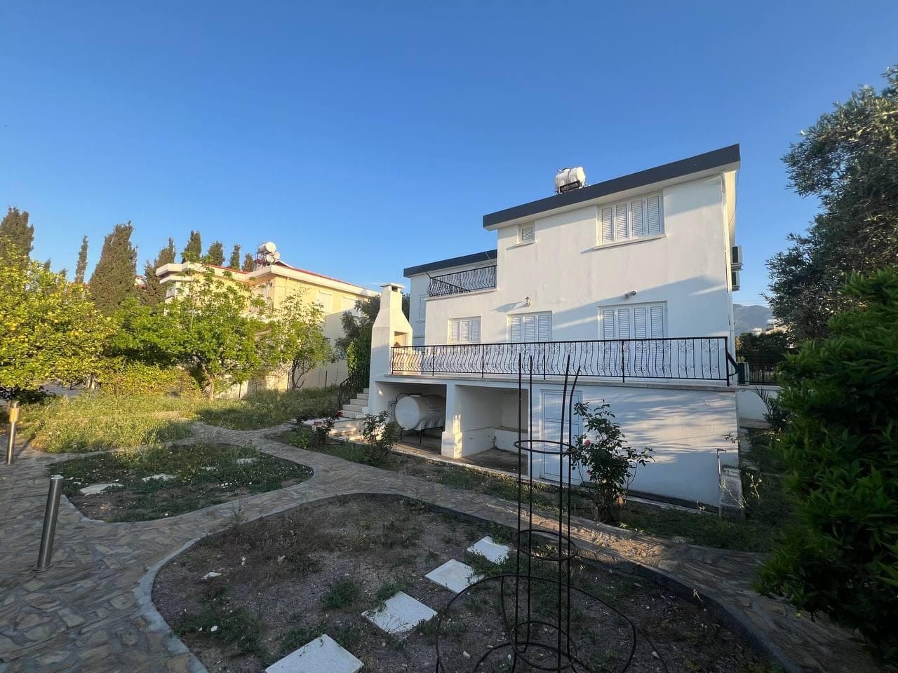 Detached villa with white facade, large garden and barbecue area