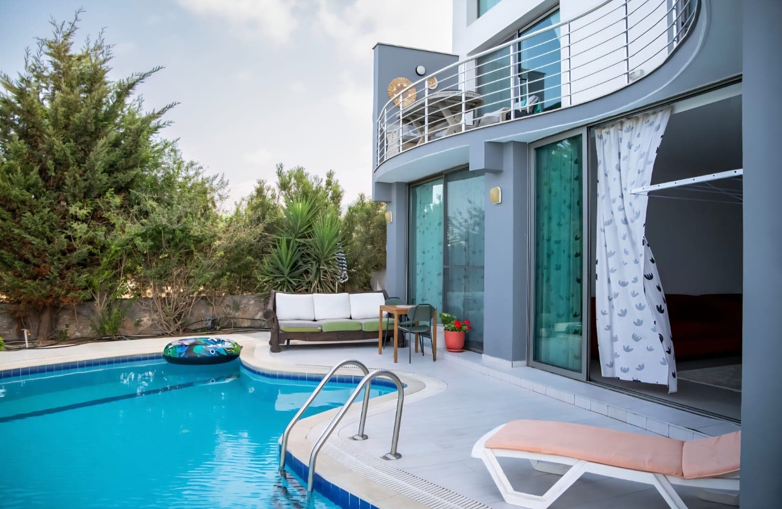 Poolside seating area and exterior with balcony on the upper floor