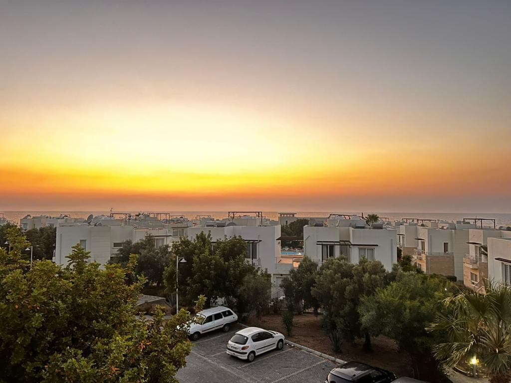 Sunset view of the complex with sea and parking area