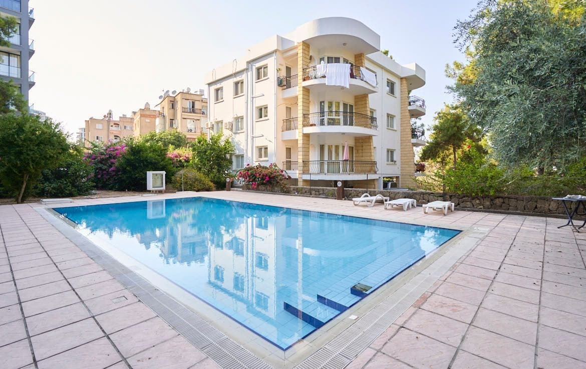 Shared swimming pool and sunbathing area in front of the apartment building.