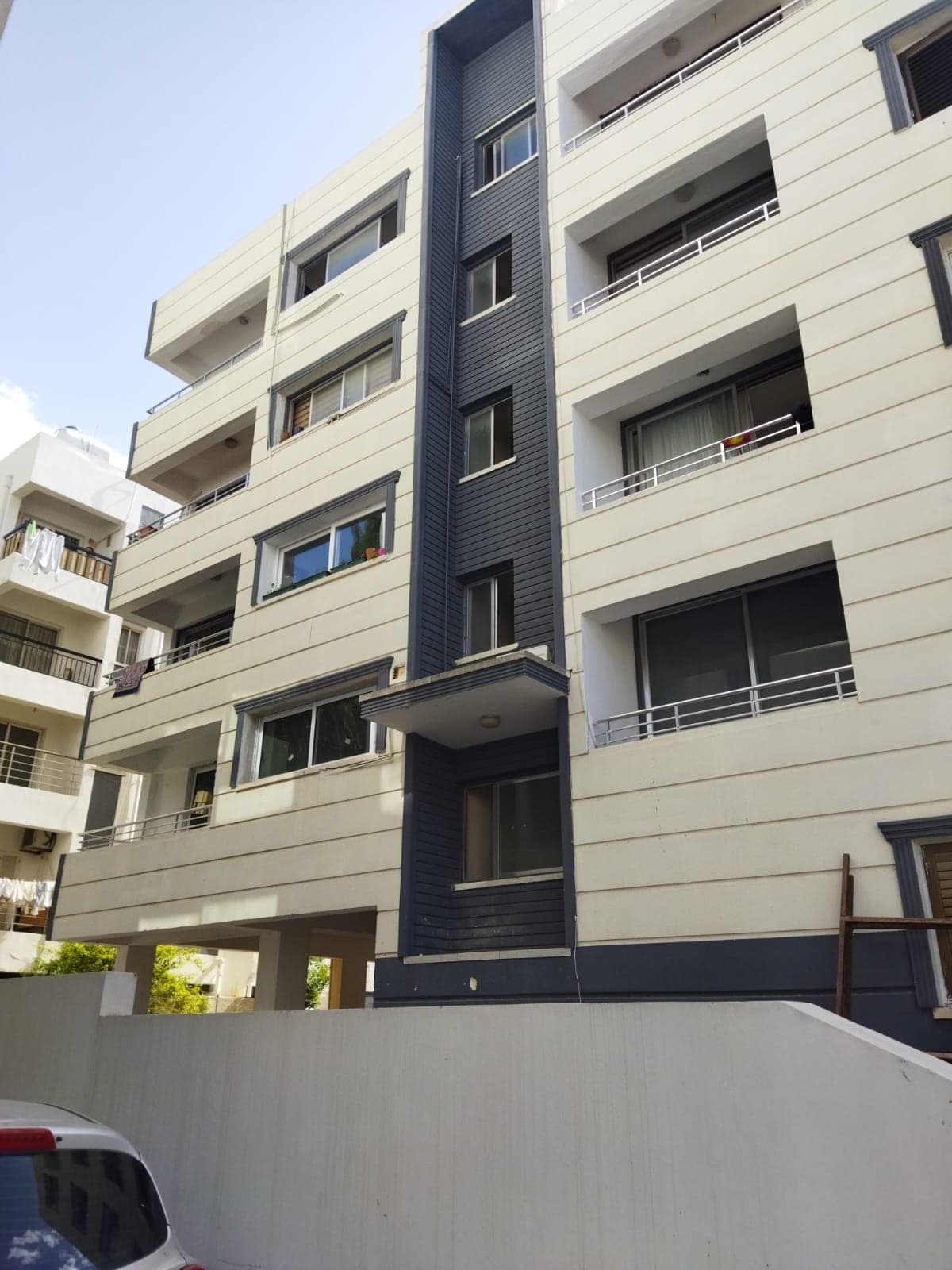 Exterior of a multi-story building with modern design and parking area.