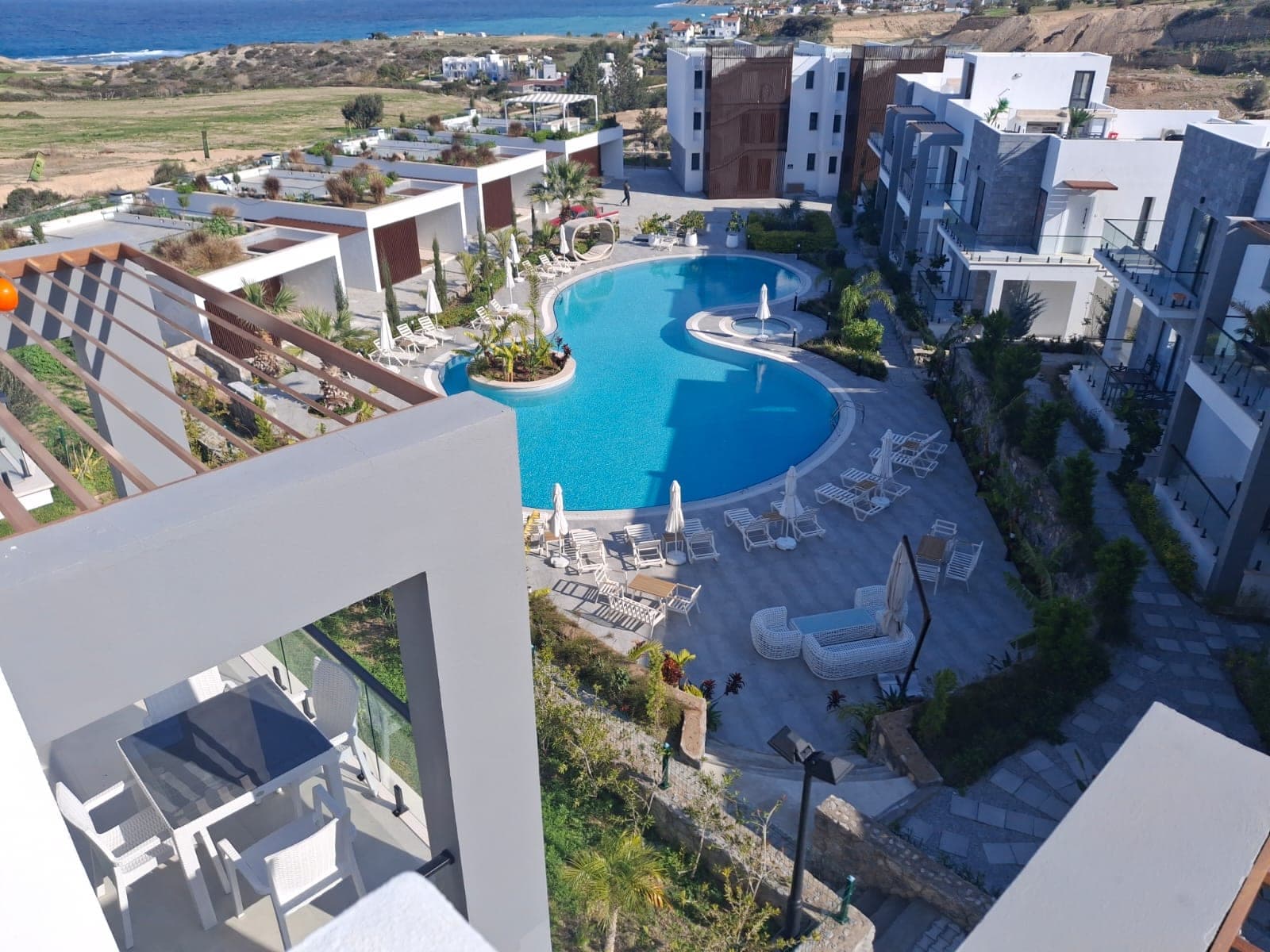 Complex's shared pool and balcony with sea view