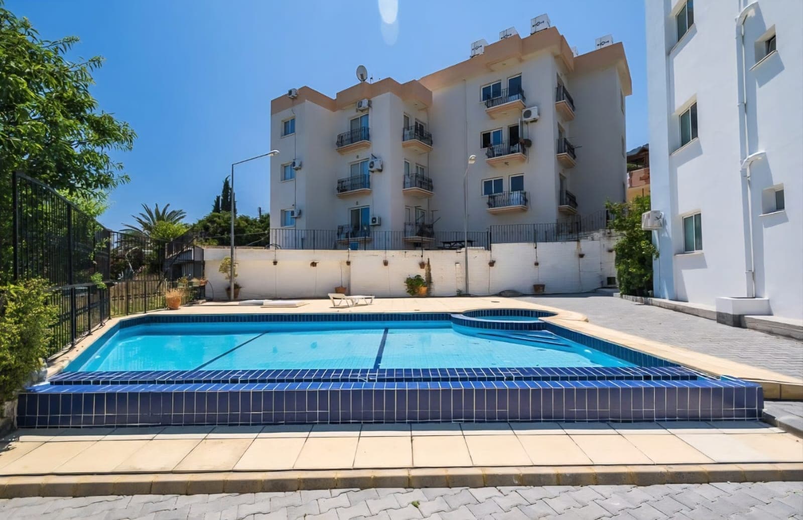 Apartman binasının önünde ortak kullanıma açık yüzme havuzu ve otopark alanı.
