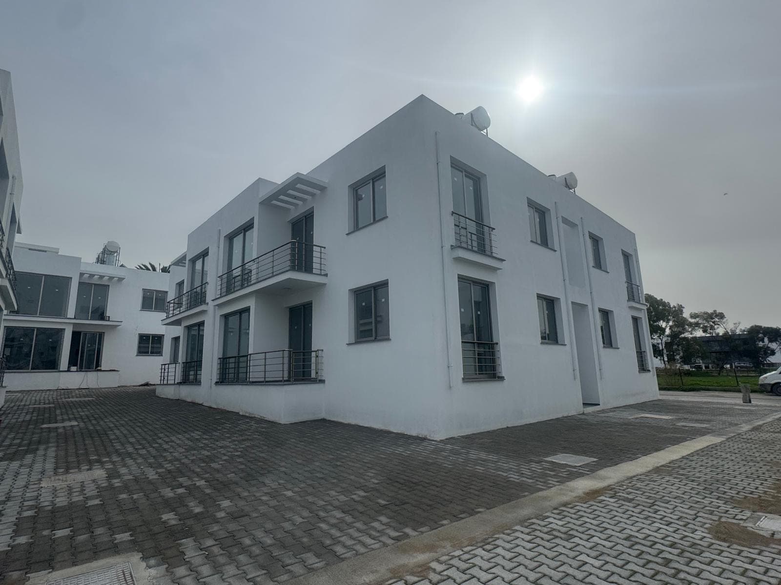 Modern designed new building with white facade and parking area