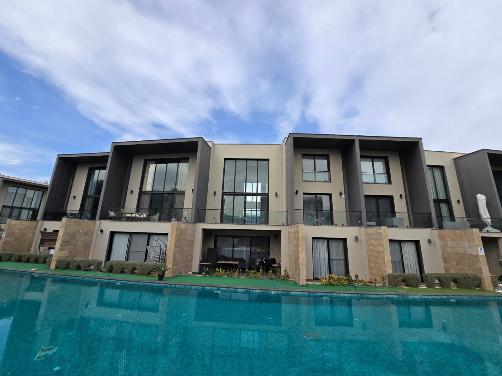 Exterior of modern apartments lined by the pool.