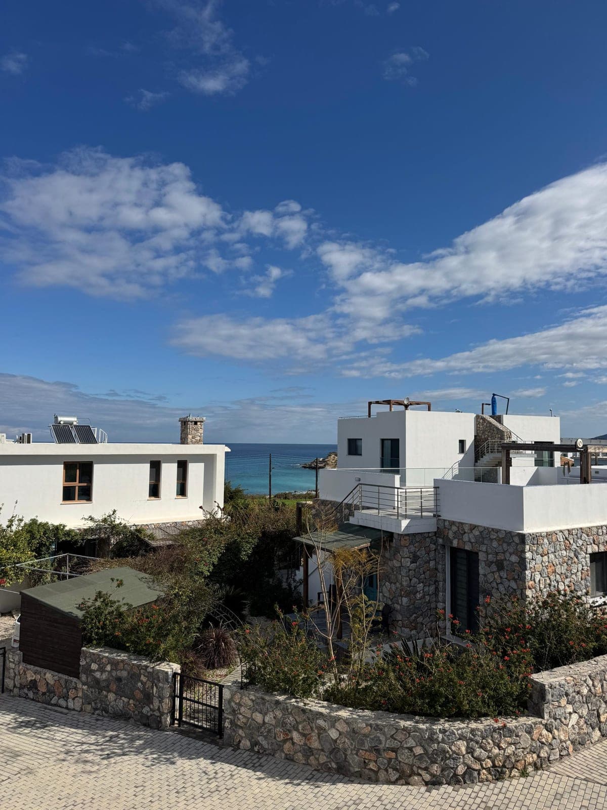 Detached houses with sea view, stone details, and white facades.