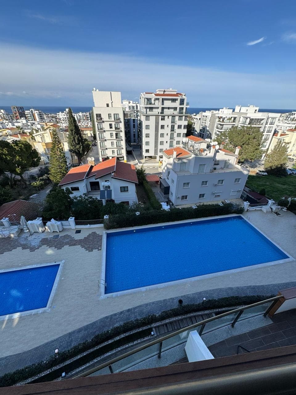 Site area with two pools and sea view, surrounding buildings