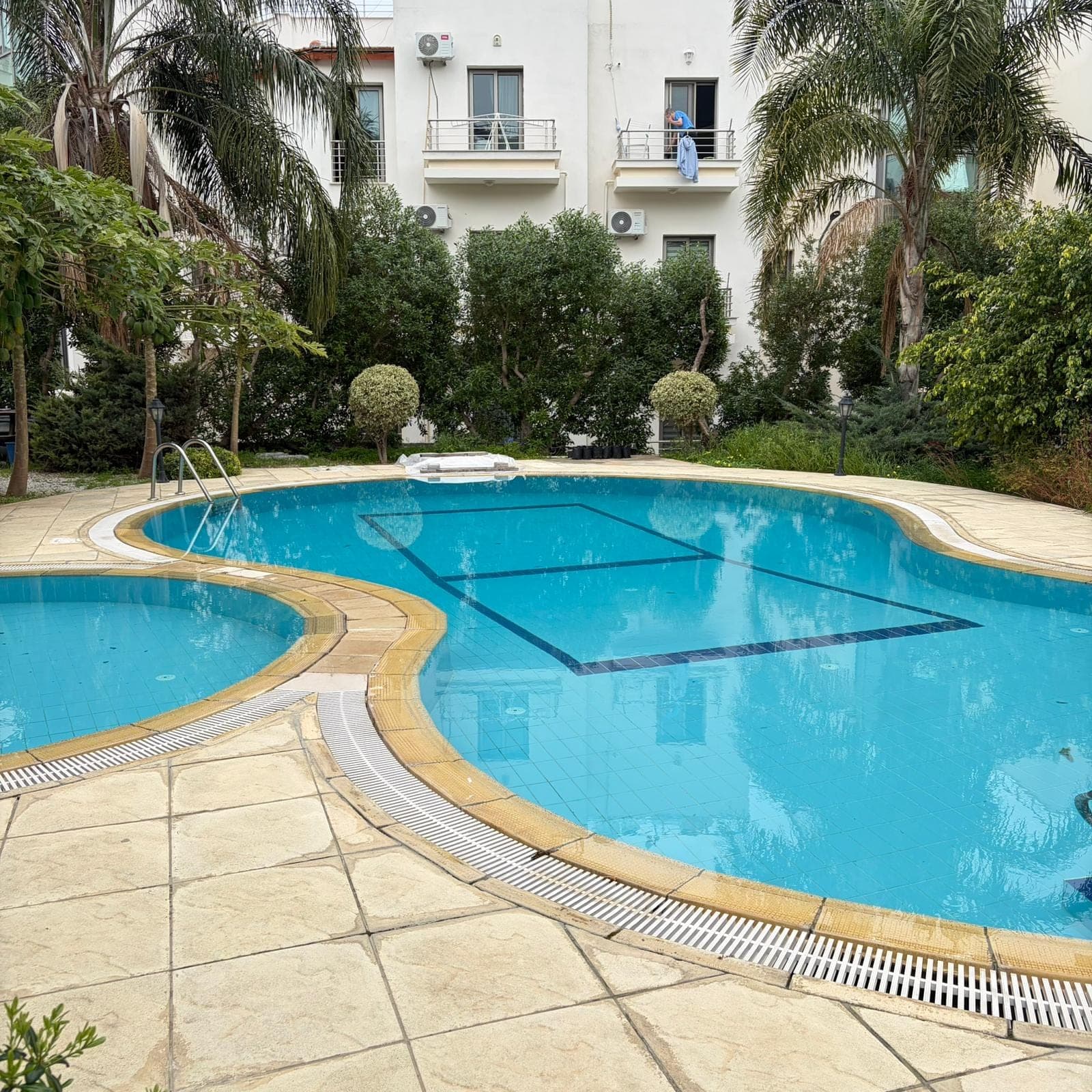 Shared swimming pool in front of the apartment building.