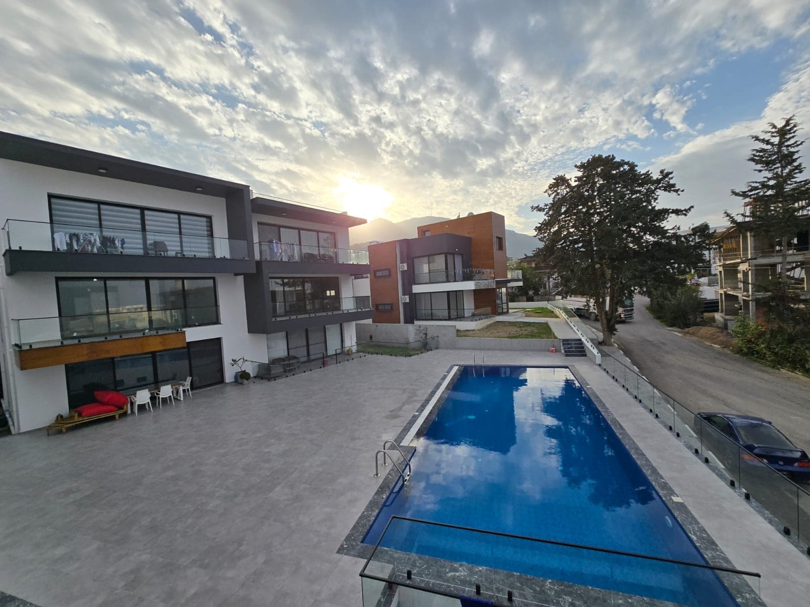 Modern apartment buildings, shared pool, and mountain view.