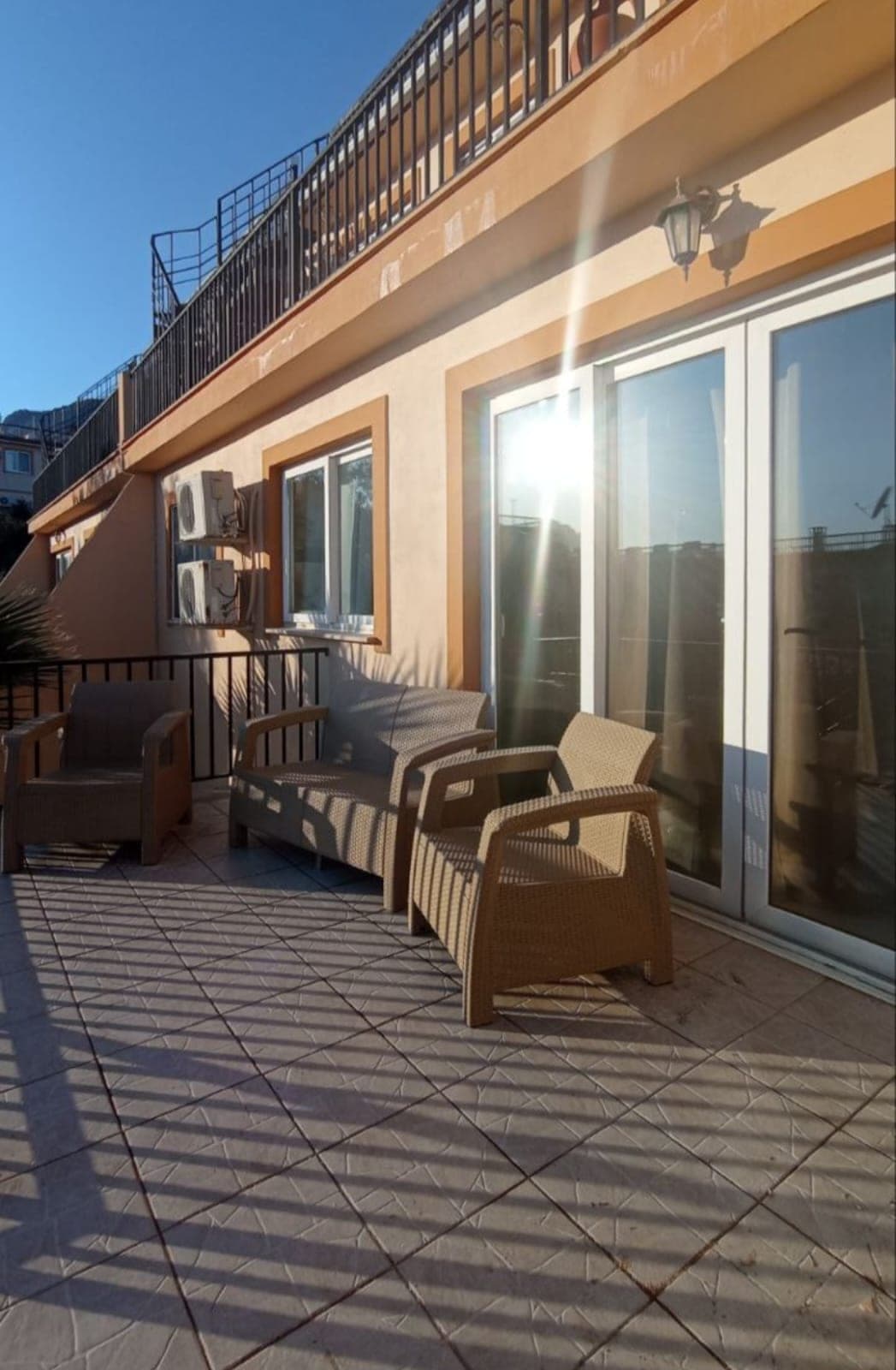 Exterior facade and balcony seating area on a sunny day