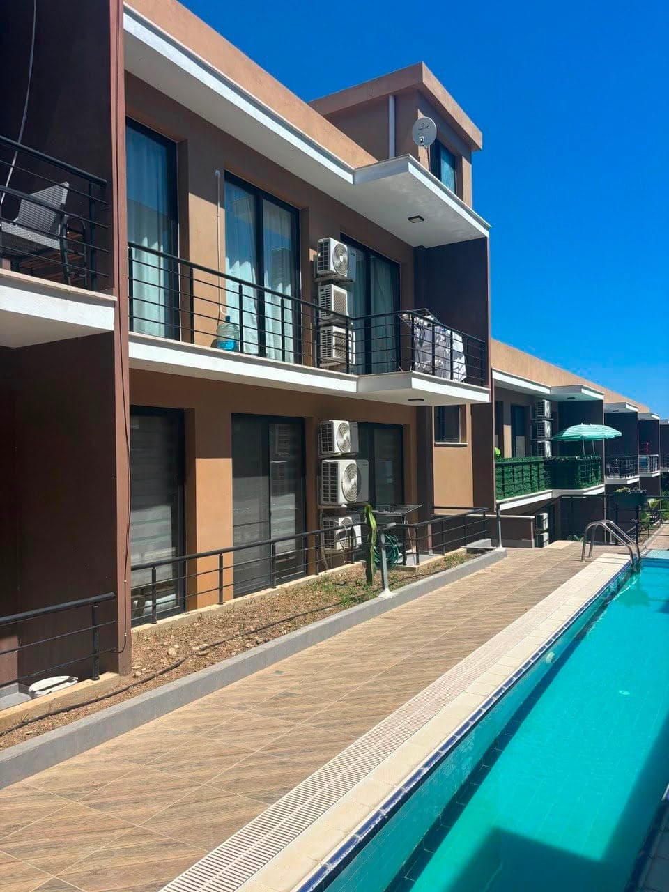 Exterior of the building with balconies and a shared pool.