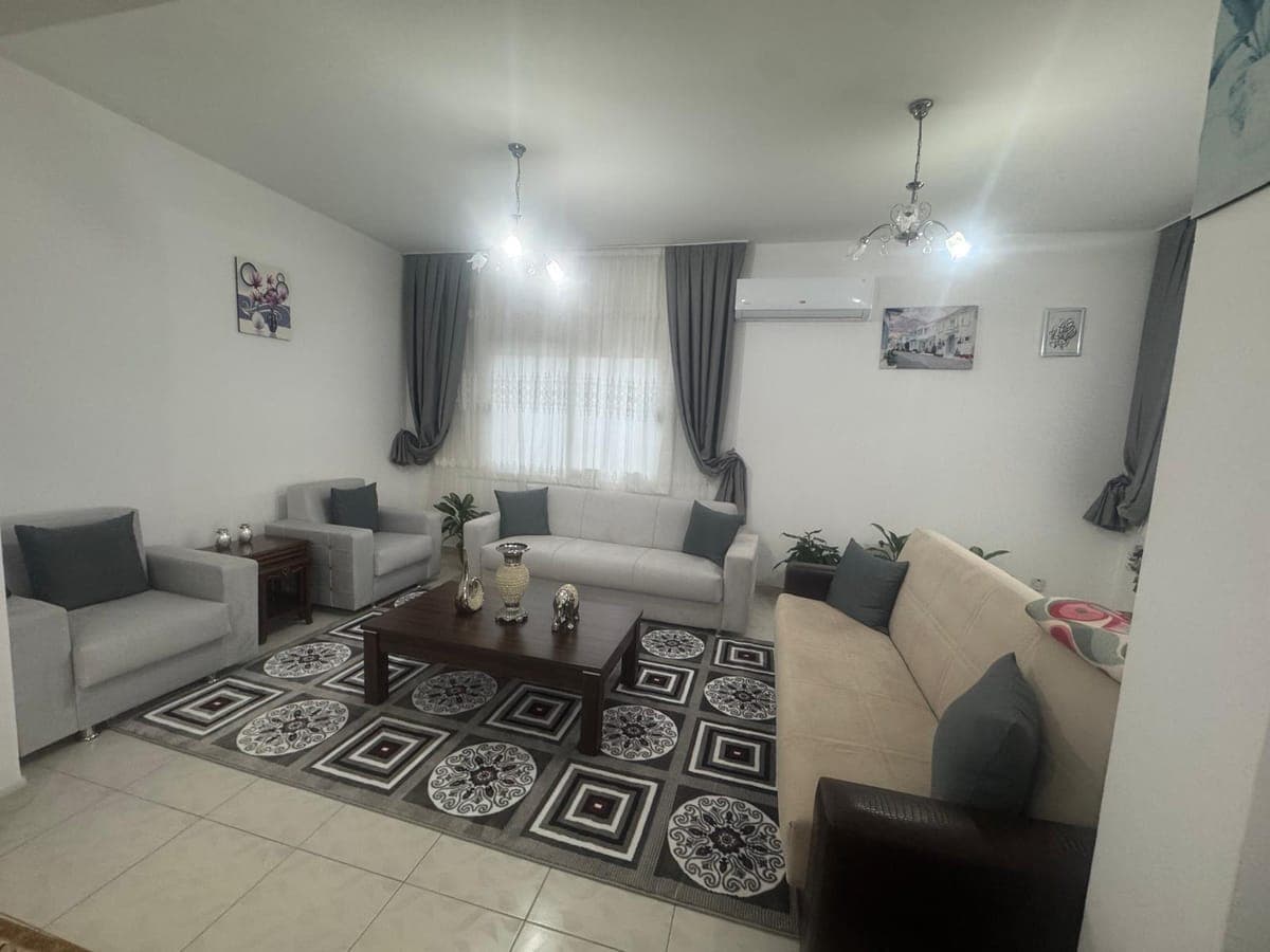 Bright living room with a spacious seating area and air conditioning.