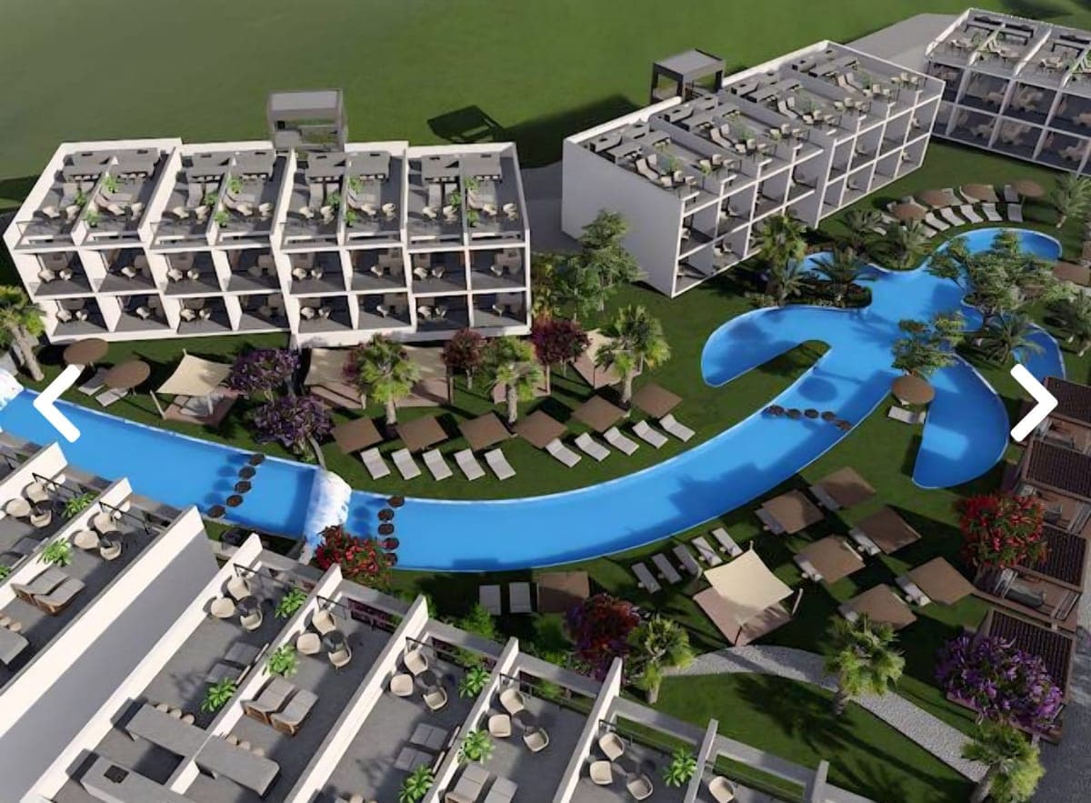Aerial view of the complex with pool, green areas, and buildings.