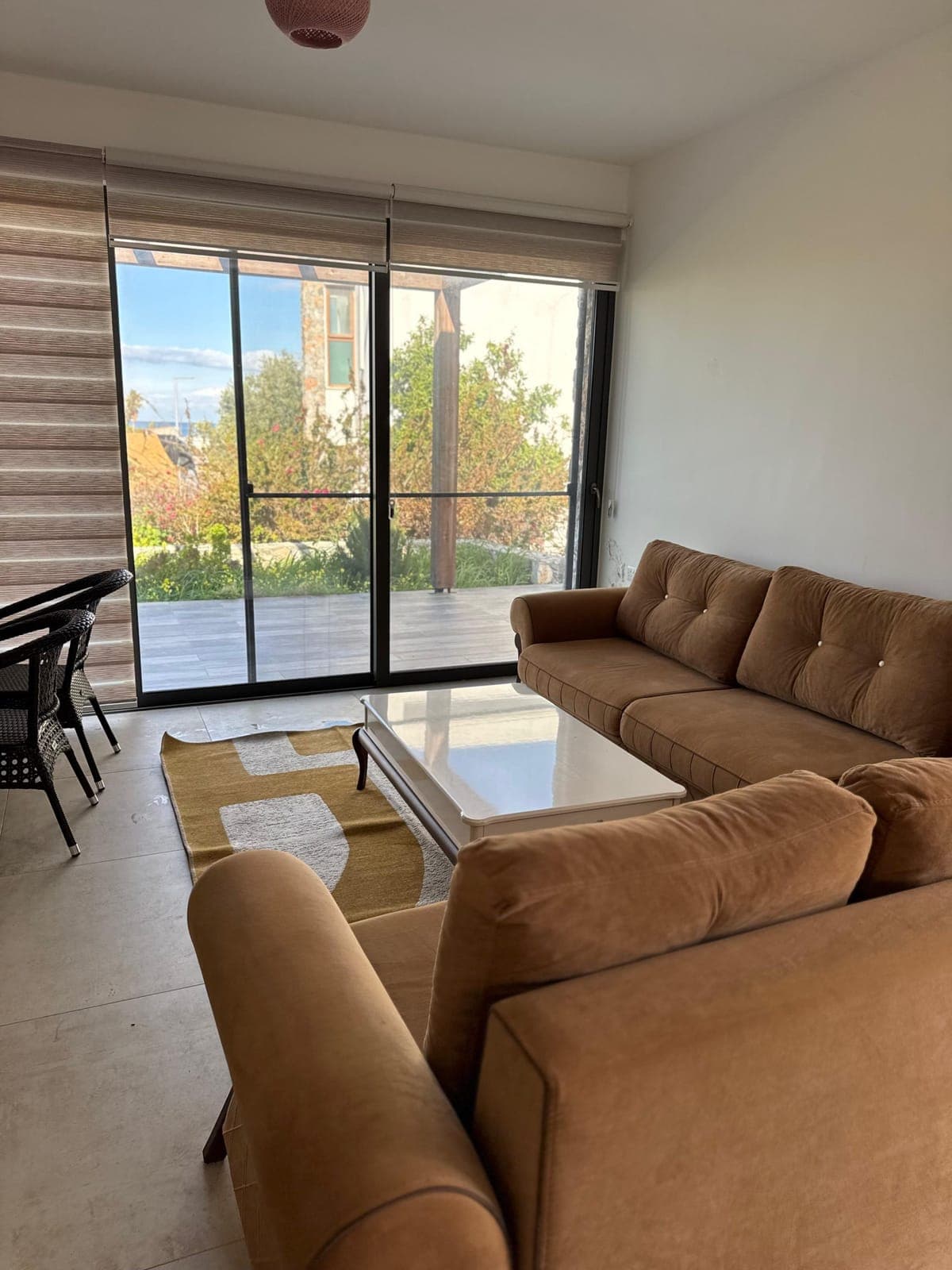 Bright living room with large glass doors opening to the garden.