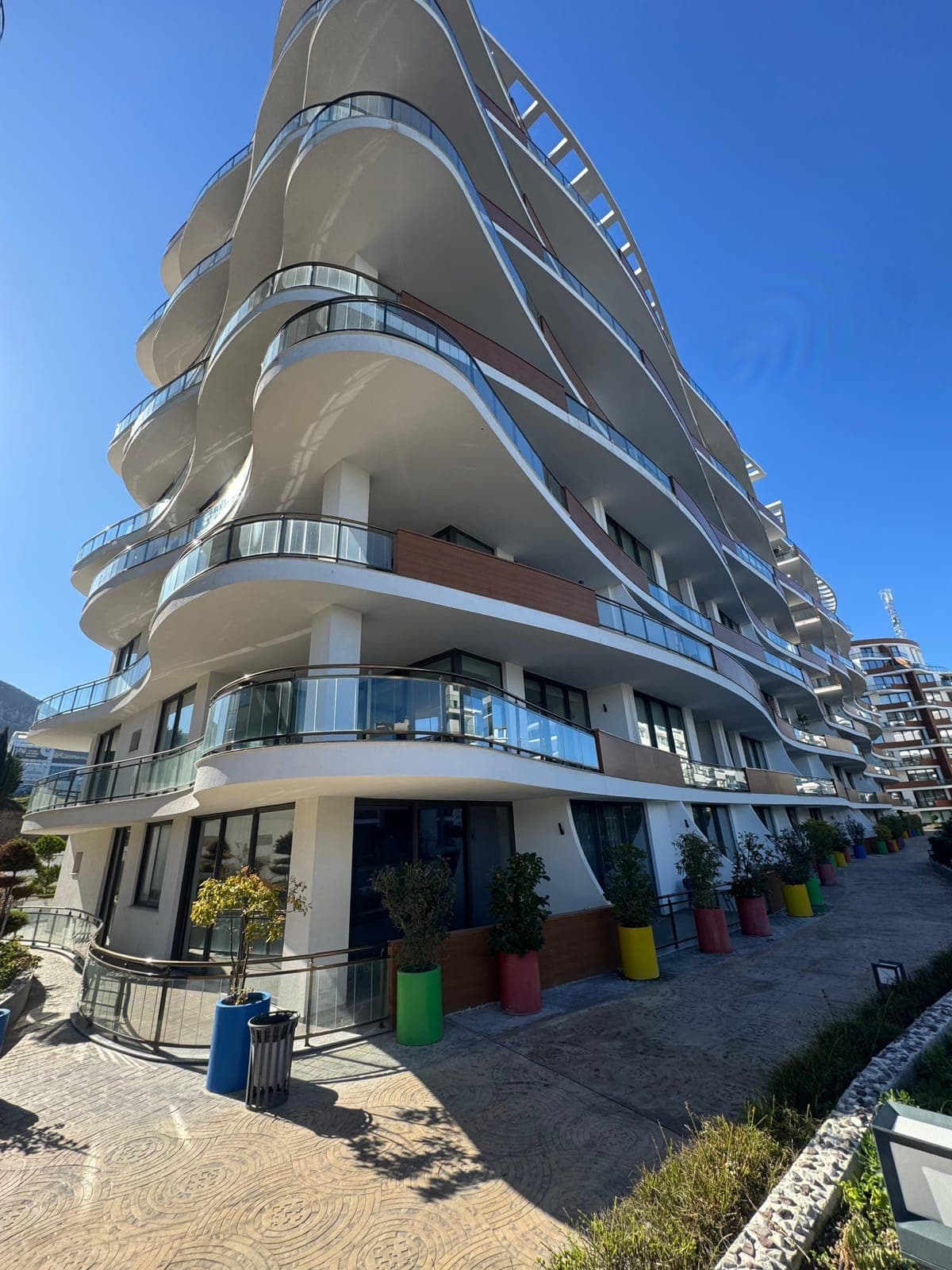 Modern mimariye sahip çok katlı binanın dış cephesi ve balkonları.