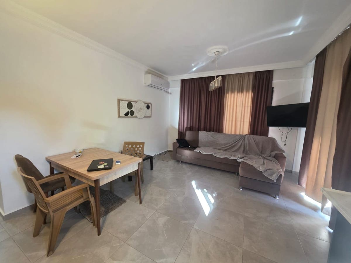 Spacious living room with seating area, dining table, and air conditioning.