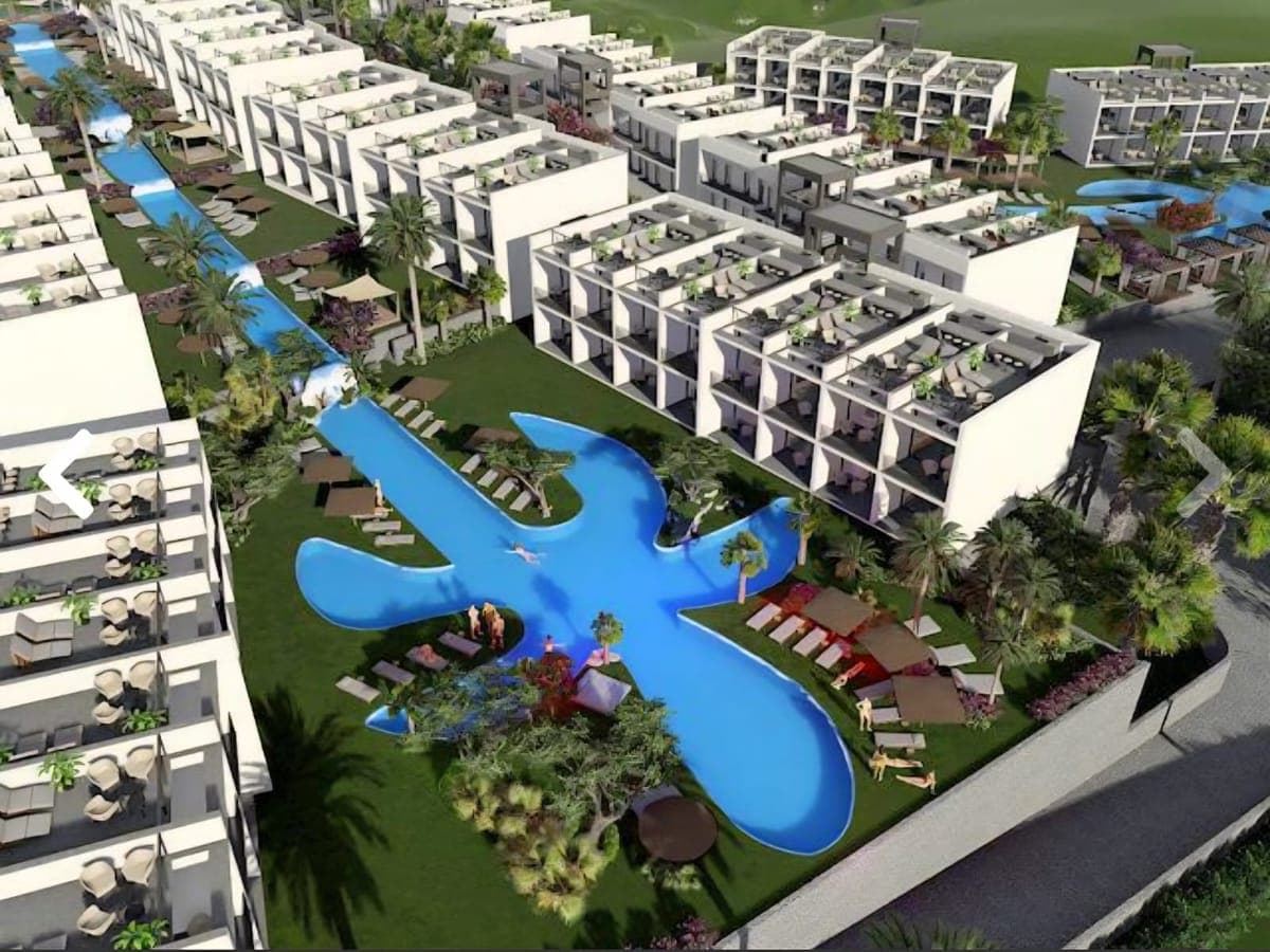 Geniş havuzlu ve yeşil alanlı modern konut sitesinin kuşbakışı görünümü.