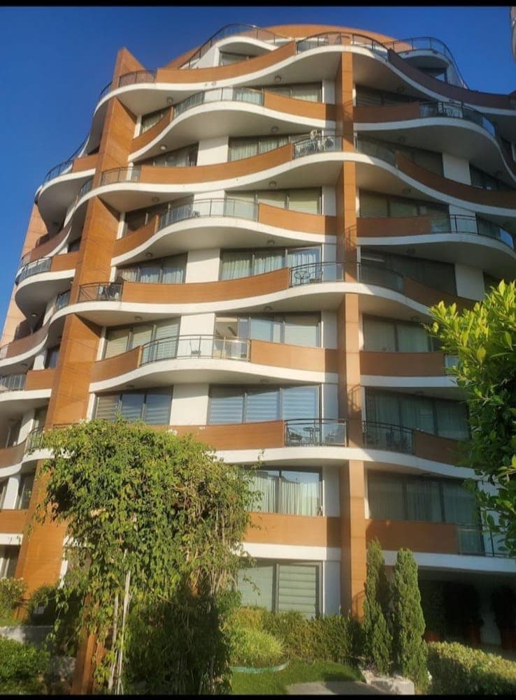 Modern mimariye sahip çok katlı binanın dış cephesi ve balkonları.