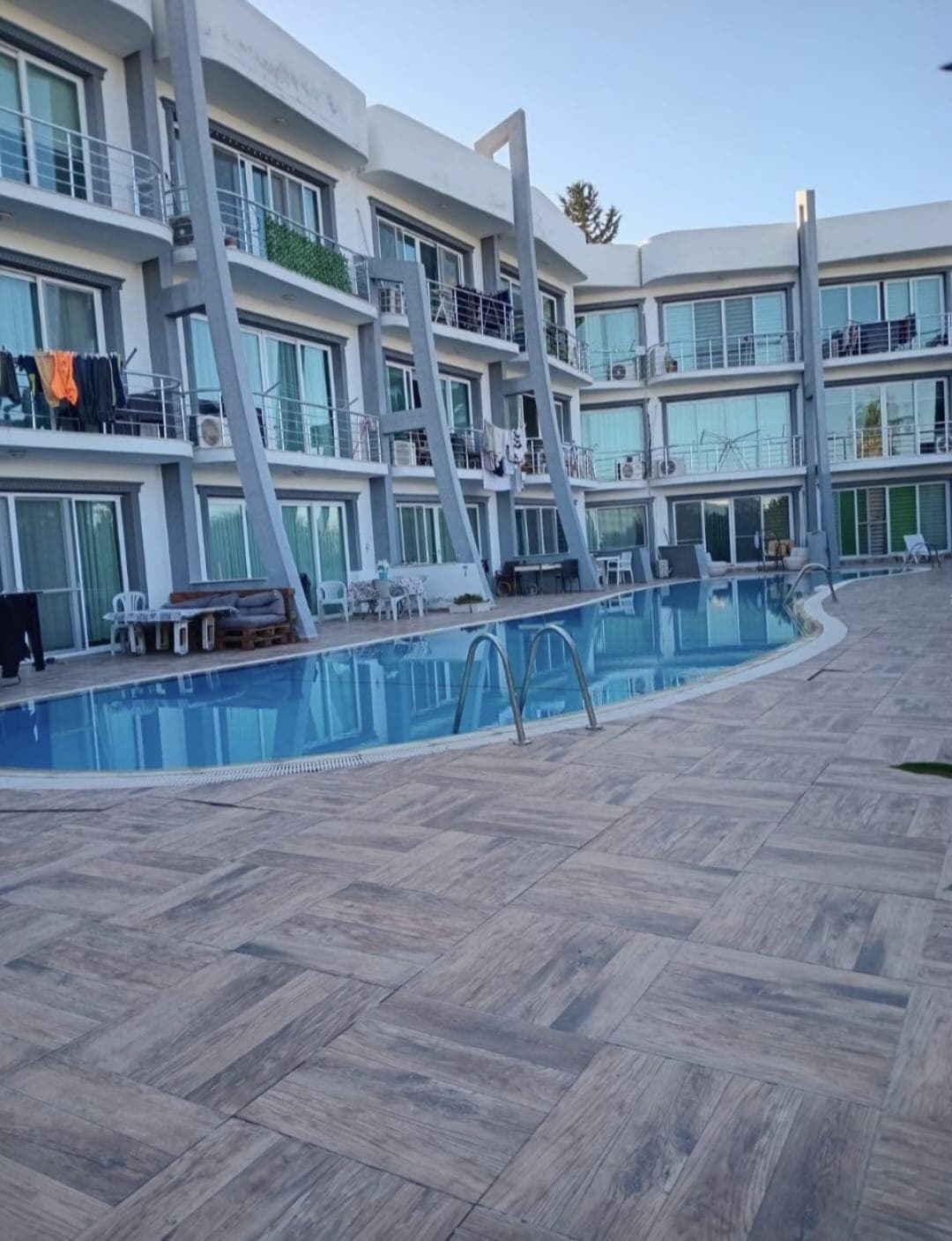 Modern apartment building with a shared outdoor swimming pool.