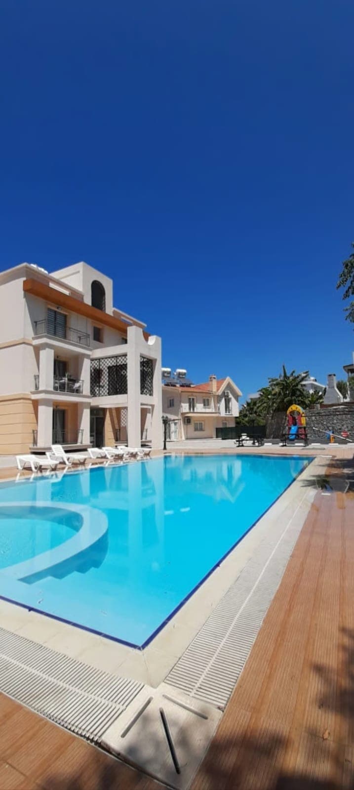 Spacious swimming pool and exterior view of surrounding residential buildings.