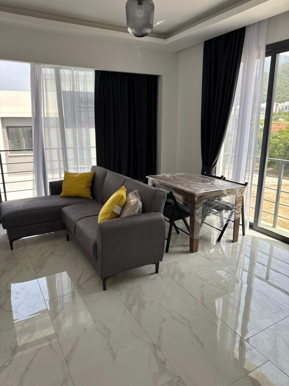 Bright living room with seating and dining area, large windows, and balcony.