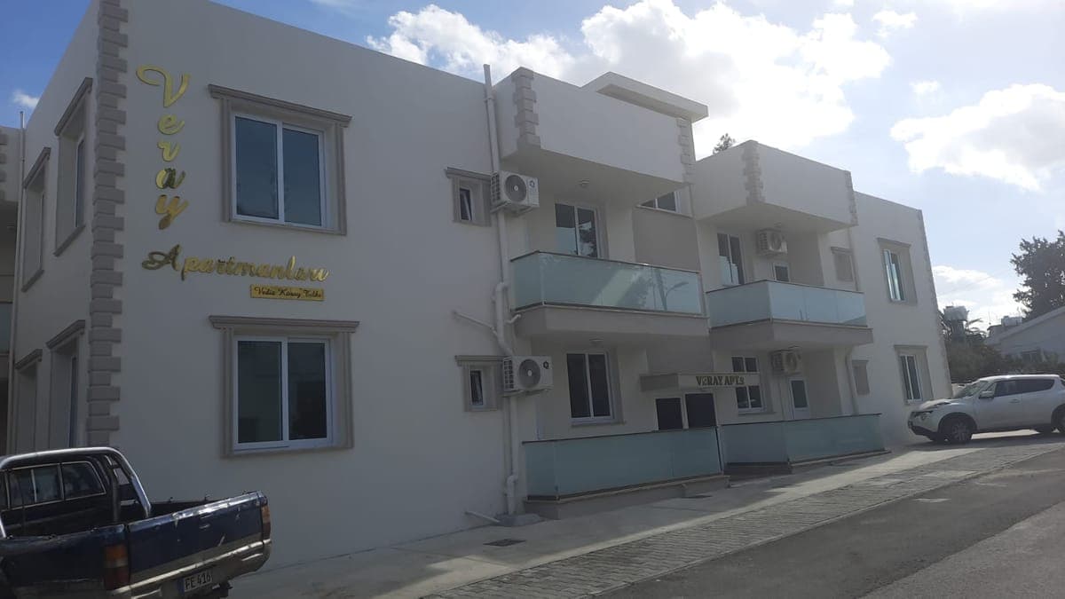 Exterior of a modern apartment building with glass balconies.