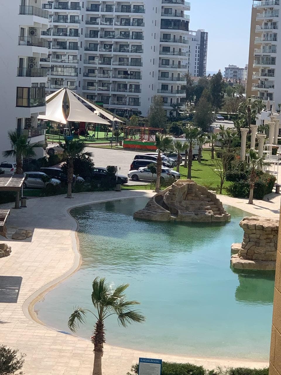 Complex pool, parking area, and surrounding residential buildings.