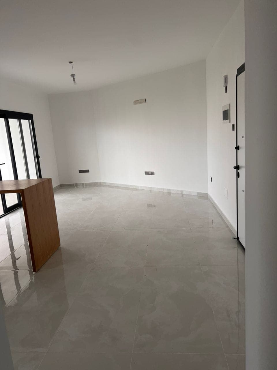 Boş, aydınlık salon alanı ve sürgülü kapı