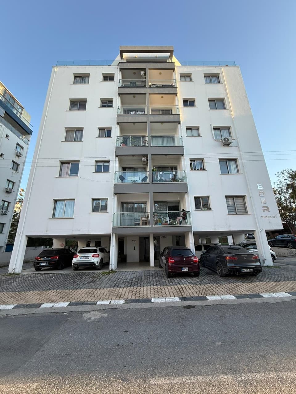 Çok katlı apartman binasının dış cephesi ve zemin kat otoparkı.